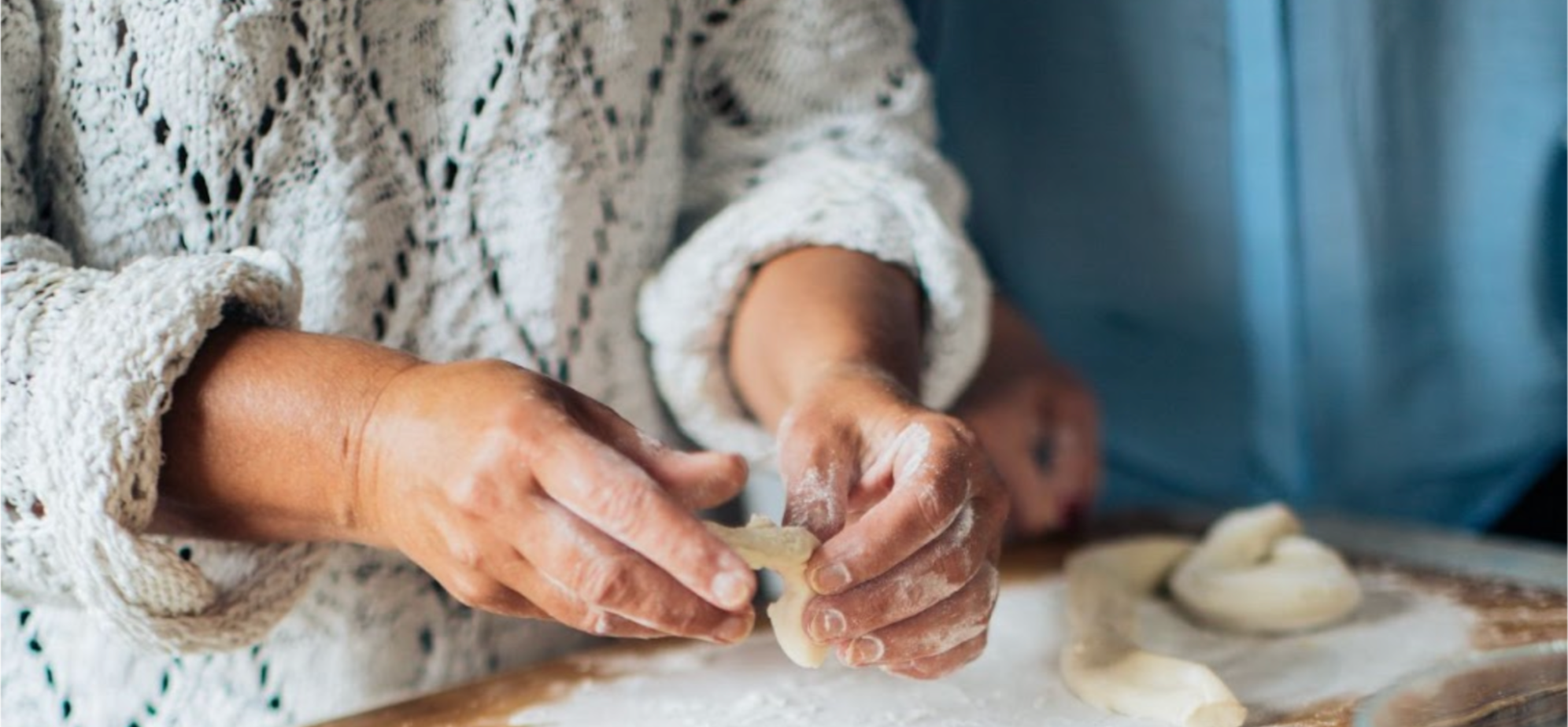 Woman in a grey jumper, baking in a kitchen