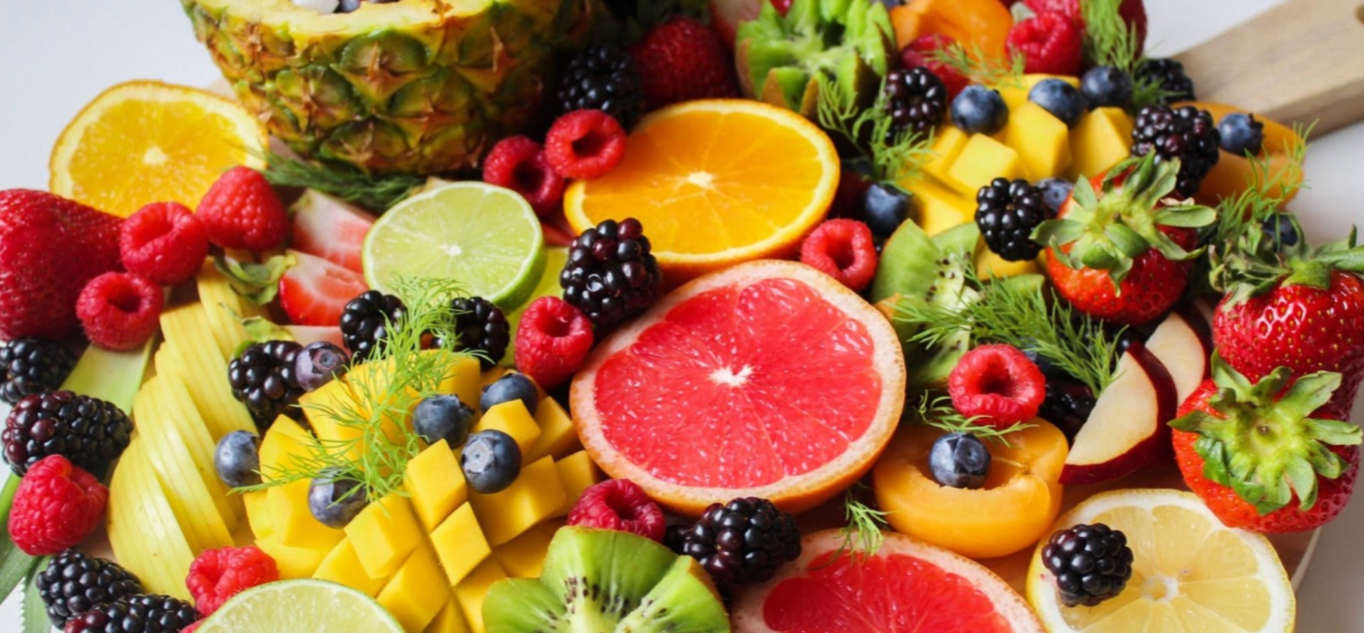Medley of fruit containing vitamin A, including lemons, oranges, kiwis, blueberries, blackberries, strawberries, limes, raspberries and pineapple