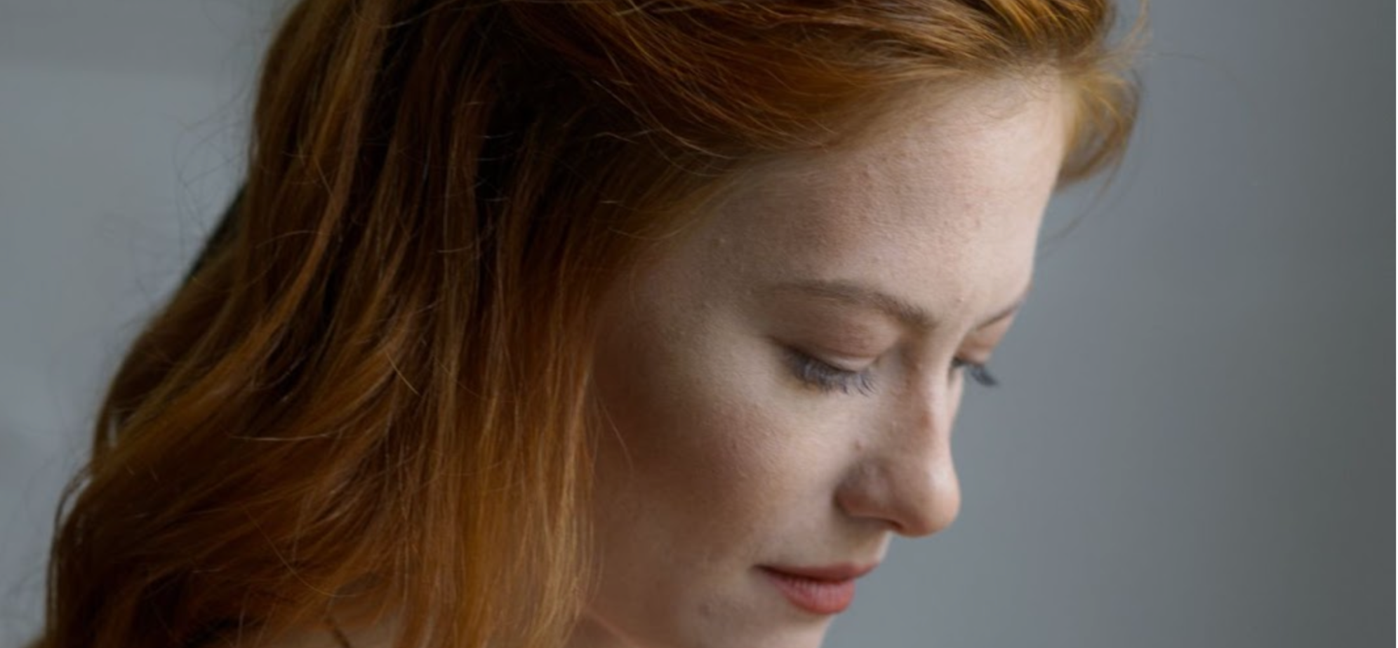 Woman with red hair looking down