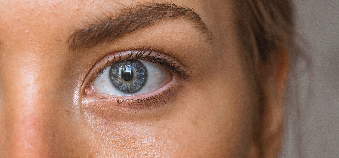 Close-up of woman’s blue eye and eyebrow with no fine lines from liquid collagen for skin.
