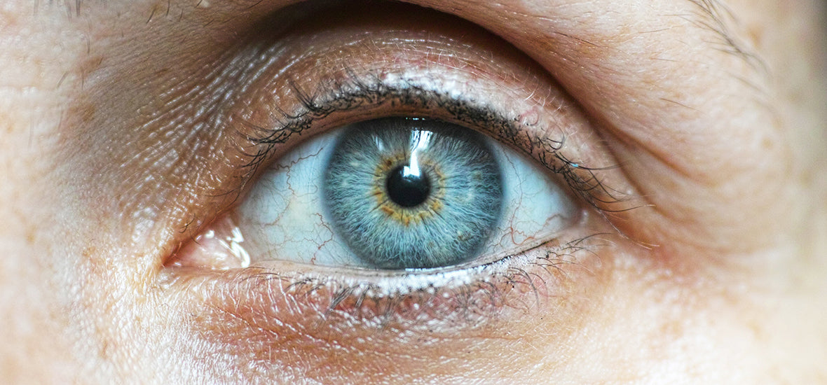 Close-up of woman’s blue eye with fine lines, showing when to start taking collagen.