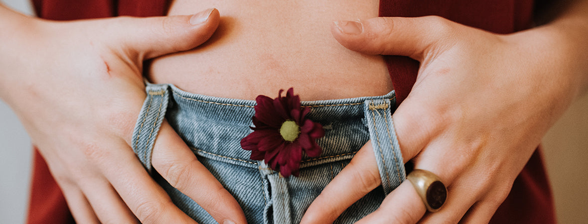 Collagen for gut health: Woman making heart shape with hands on her stomach.