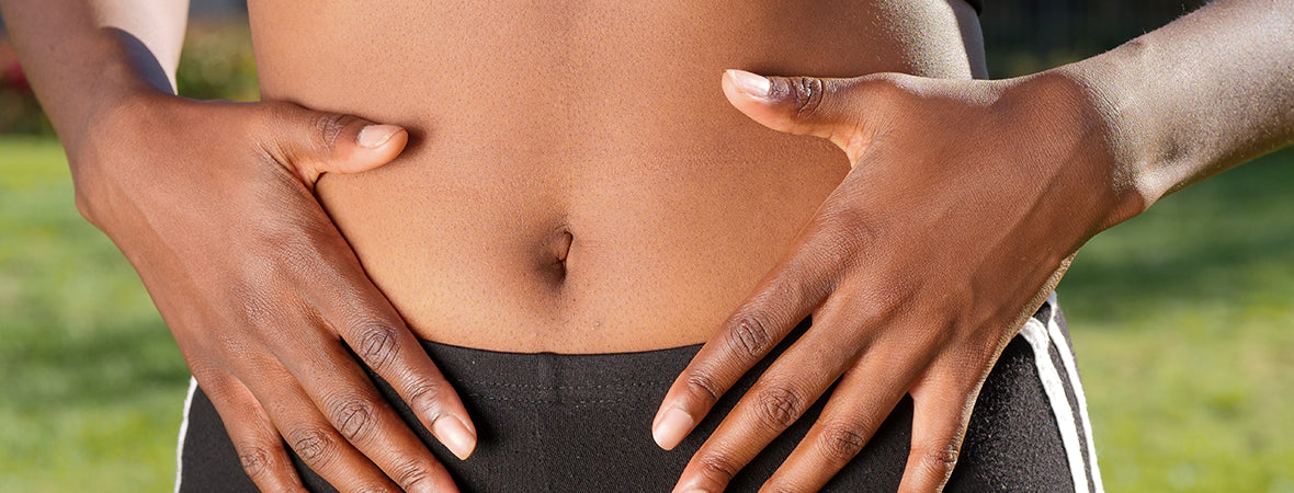 Collagen for gut health: Woman placing hands on her bare stomach.