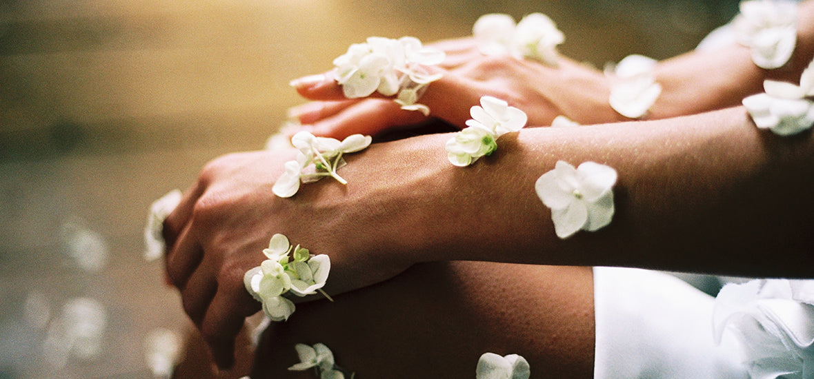 Boost collagen: person sitting cross-legged with white flowers on their skin.