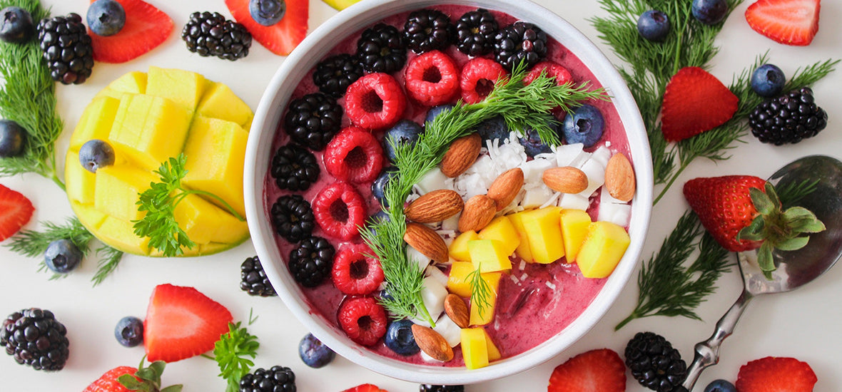 Yoghurt bowl of blackberries, raspberries, mango, almonds and blueberries for vegan collagen foods.