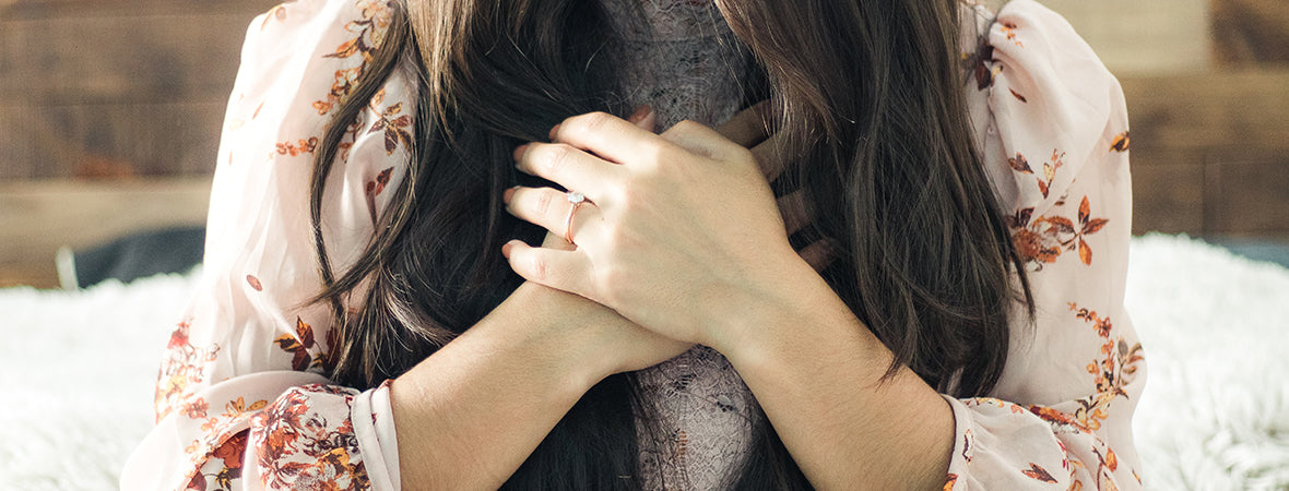 Collagen: Woman with long brown hair and her hands over her heart.