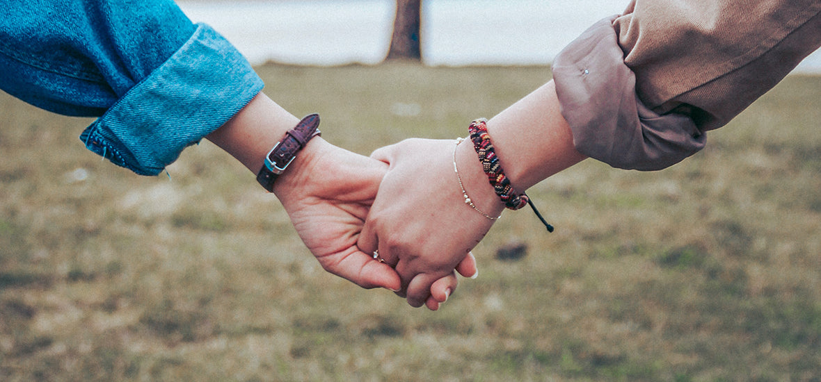 Women holding hands, supporting each other to reduce hormonal stress.