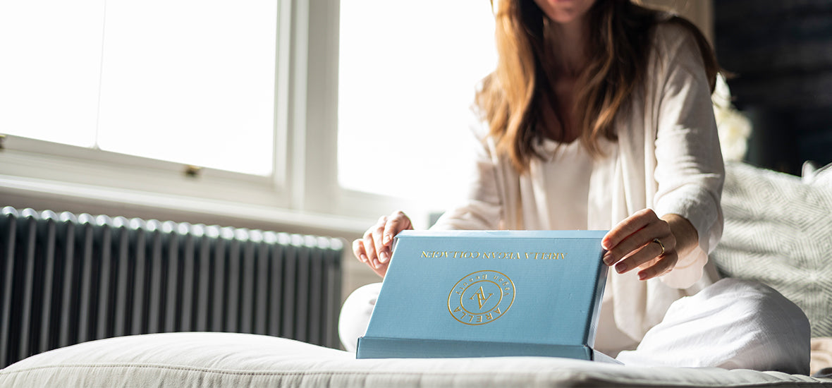 Woman opening a box of Arella vegan collagen.