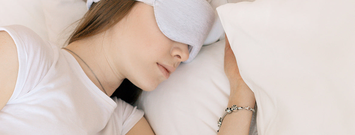 Collagen for gut health: Woman sleeping wearing a white top with white bedsheets and white sleeping mask.