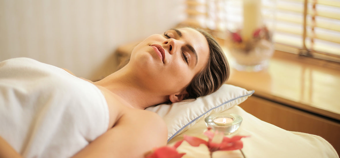Woman on a massage table looking relaxed to help cope with stress.