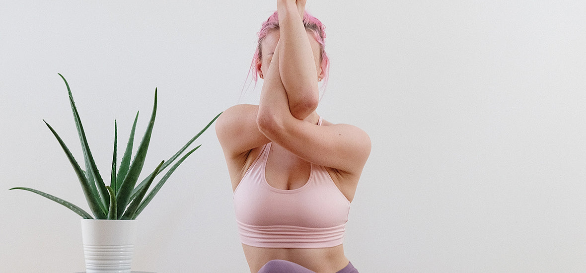 Different types of collagen - woman doing arm twists in yoga with plant in the background.
