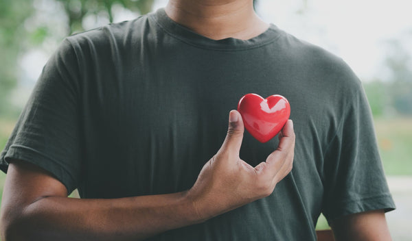 A Farmer holding a red heart over his chest.