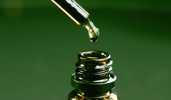 a tincture of full-spectrum CBD Oil on a green background