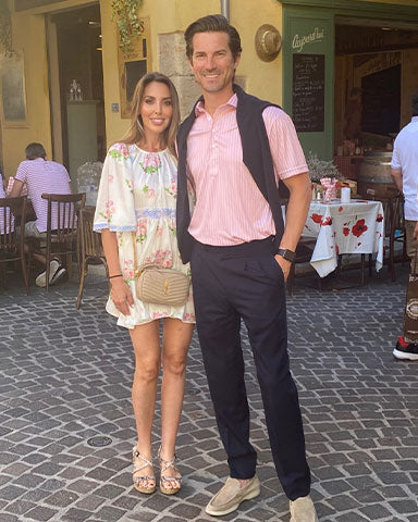 ceo justin baer wearing pink and white stripe polo with wife in europe
