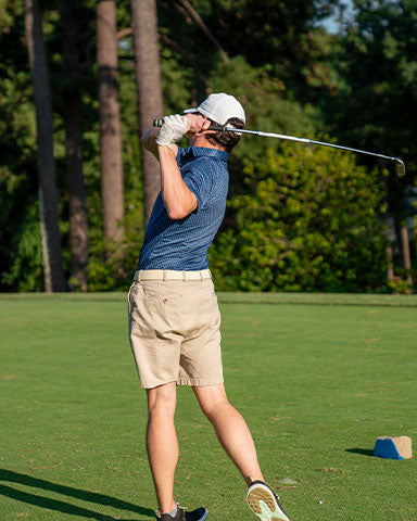 man wearing blue pattern golf polo hitting hole in one in georgia