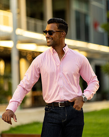 man wearing pink dress shirt outside horse track of kentucky derby