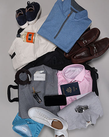 suitcase unpacked with men's clothes and accessories