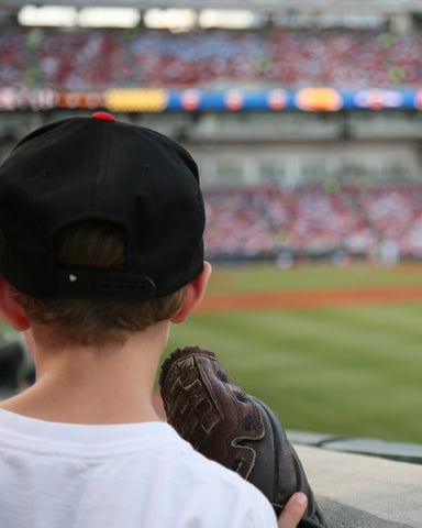 boy watching baseball game with baseball glove at stadium mlb 2024
