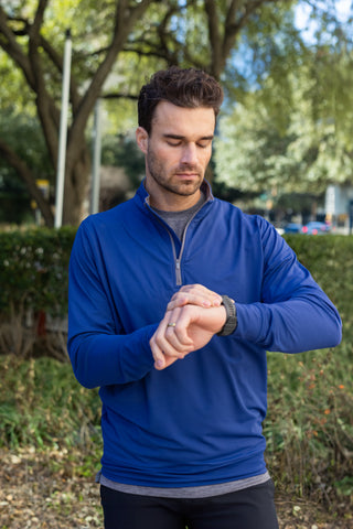 man checking watch in activewear, getting ready for a run