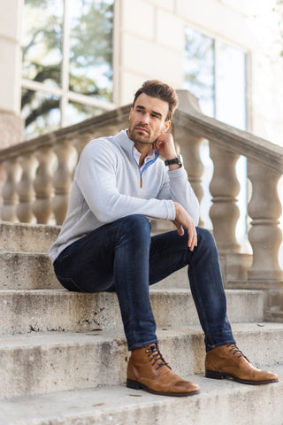 man sitting on marble stairs outside building while wearing the zen reversible pullover