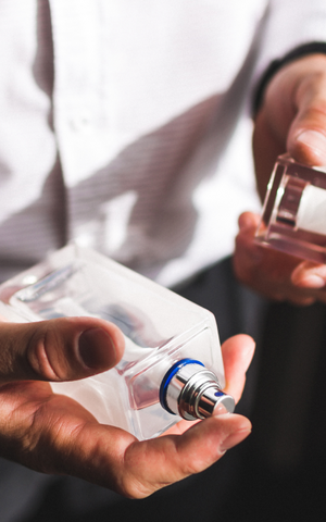 man holding a cologne bottle