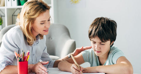 a lady helping a young boy with reading