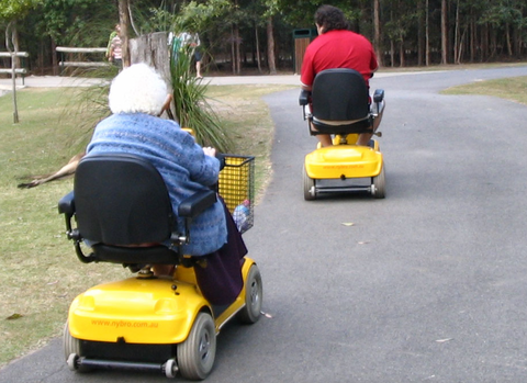 2 people on yellow mobility scooters