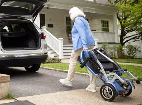 women putting so lite scooter in the back of the car