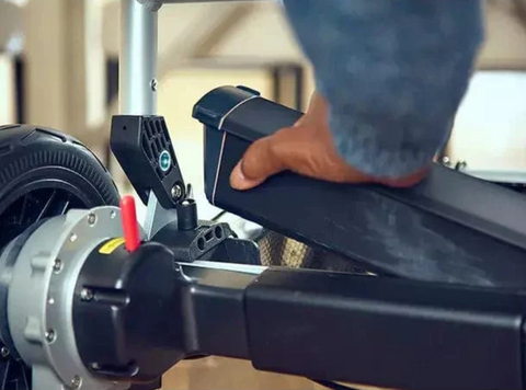 man pulling out battery from wheelchair