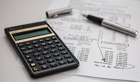 Calculator on top on paper with budget numbers