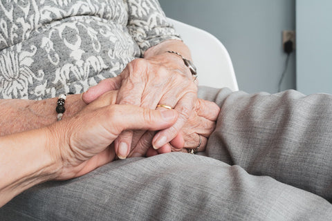 Person holding elderly women's hand