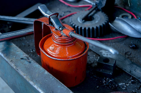 Red lubricator can on a work bench