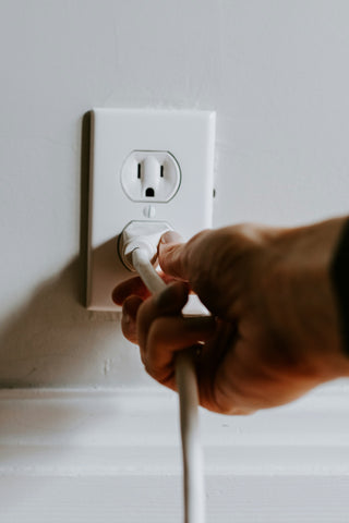 outlet with person plugging in cord