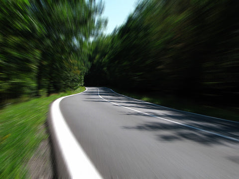 road with blurred trees showing speed