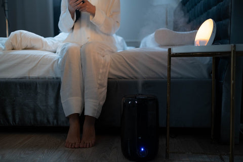 A person using a smart humidifier in their bedroom