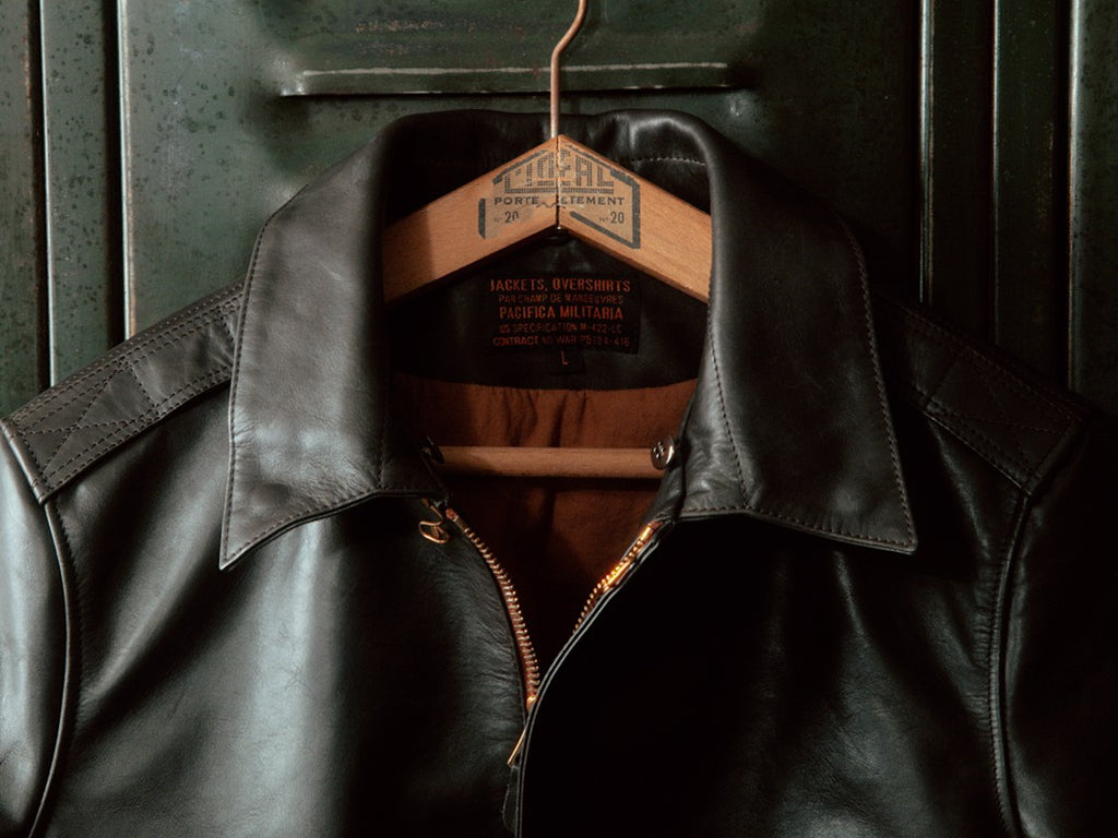 Zoom on the collar of the bomber jacket, unbuttoned and decorated with Deadstock buttons made in the United States.