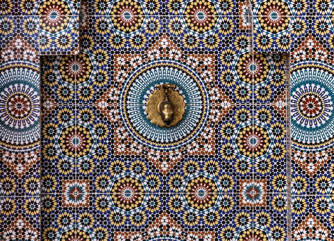 geometric art tiles around a golden faucet. Geometric designs are a perfect way  to add a touch of culture in your home, inside and outdoors.