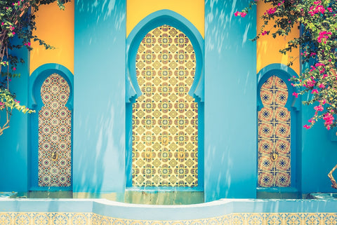 travel to Arabia or Morocco and you can see horseshoe arches tiled with geometric patterns and artwork pictured here with a contrast of bright aqua frames and yellow accents on the tilework and walls. 