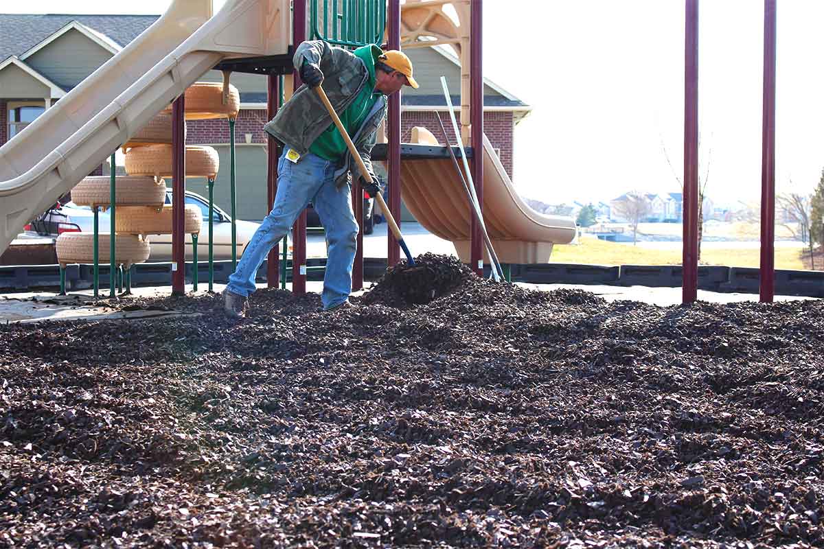 Spreading rubber mulch on playground