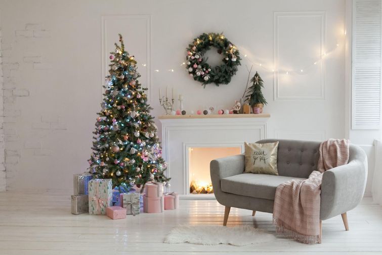 Fresh Christmas wreath hanging above marble fireplace