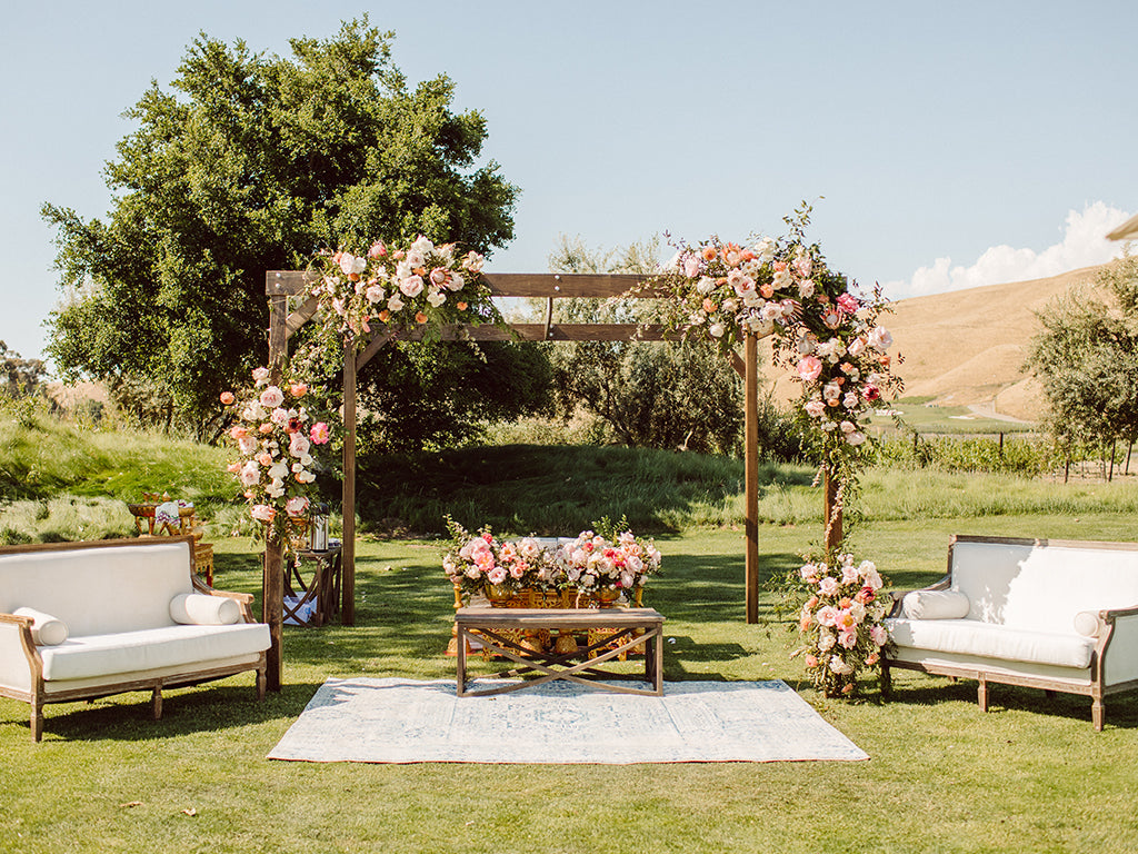 Love Life & Bloom A & J tea ceremony altar with flowers and couches