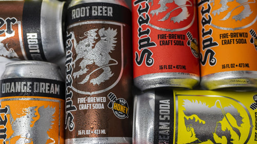 Cold sweating cans of Sprecher Root Beer, Cream Soda, Orange Dream, and Cherry Cola