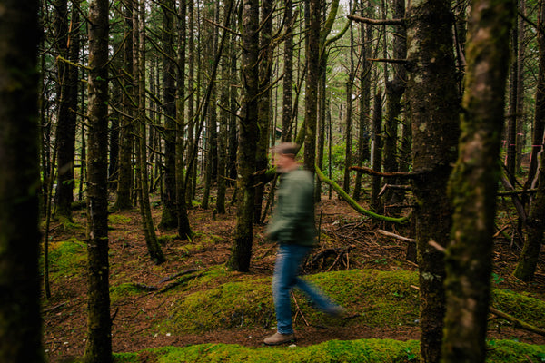 man walking through trees in forest