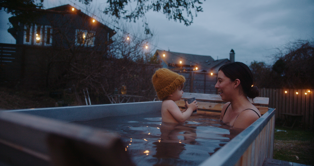 Jordyn and her son in their GOODLAND Wood Burning Hot Tub at dusk