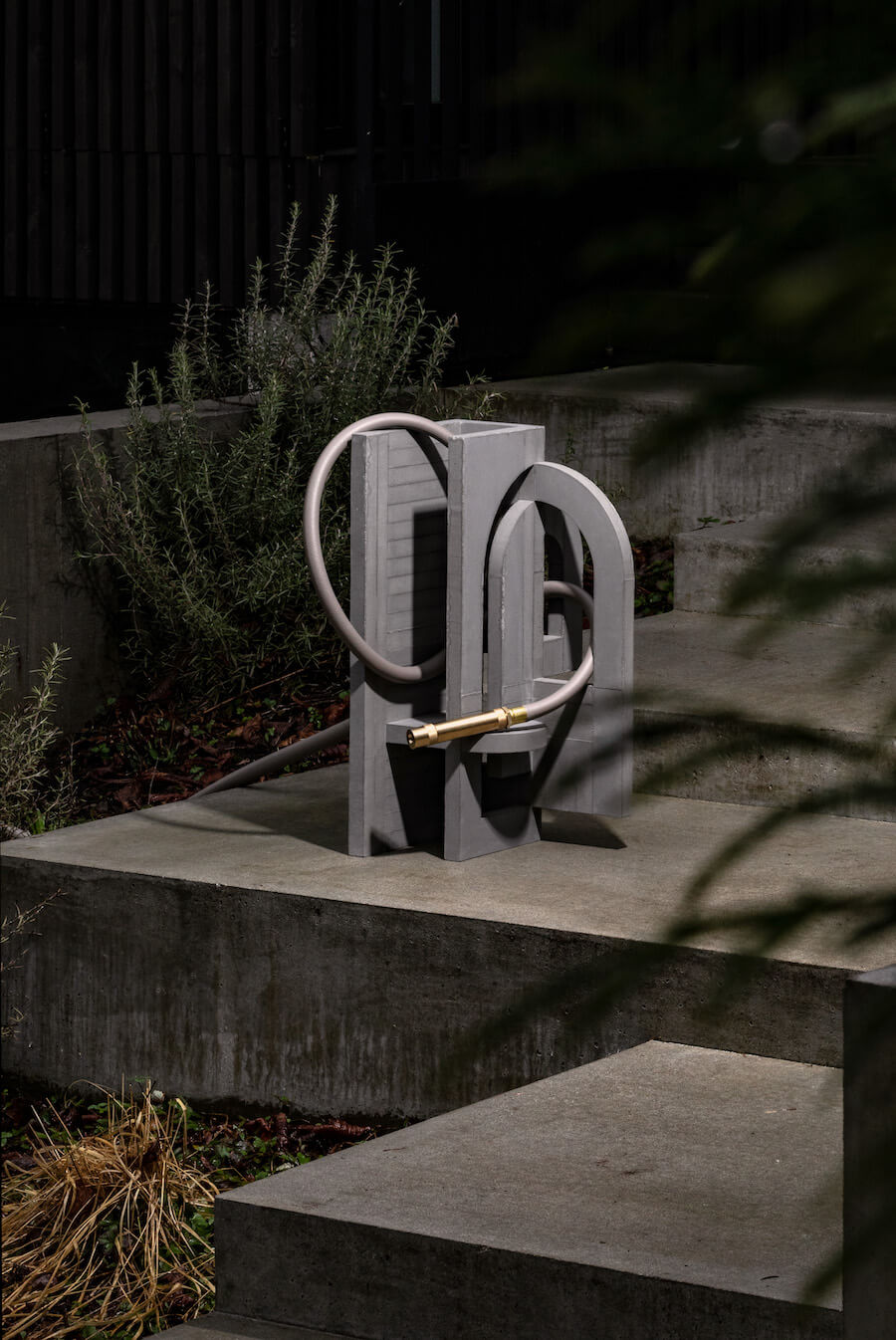 concrete sculpture and grey garden hose