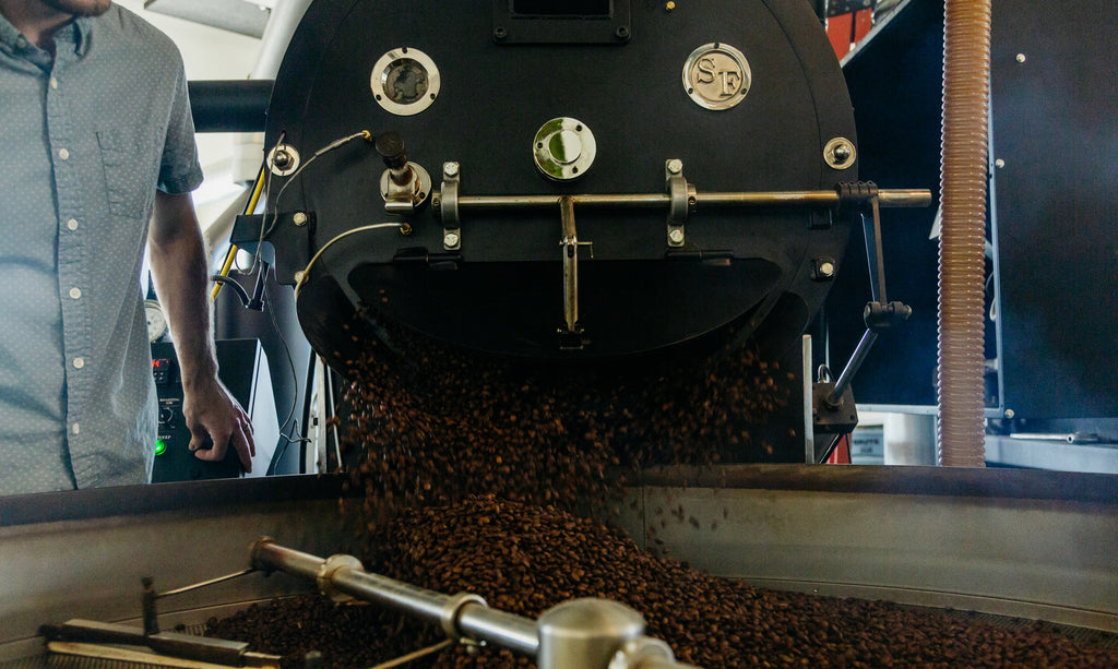 Freshly roasted coffee beans coming out of roaster