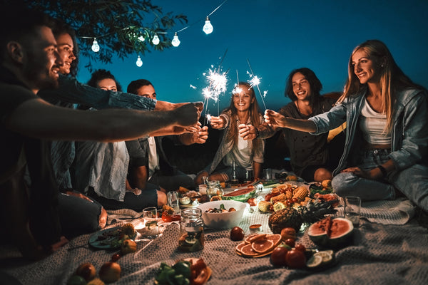 friends enjoying a picnic at night while having a 30th birthday outdoors
