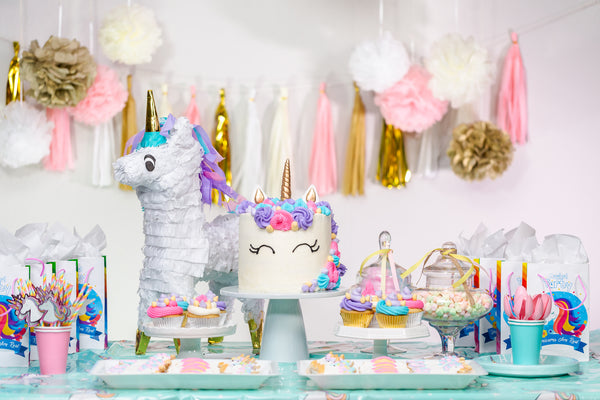 Dessert table for a unicorn-themed party for a babys first birthday