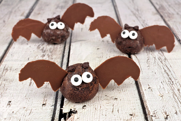 three halloween-themed truffles in the shape of bats