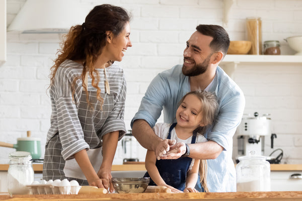 Happy woman and man baking cookies with their child